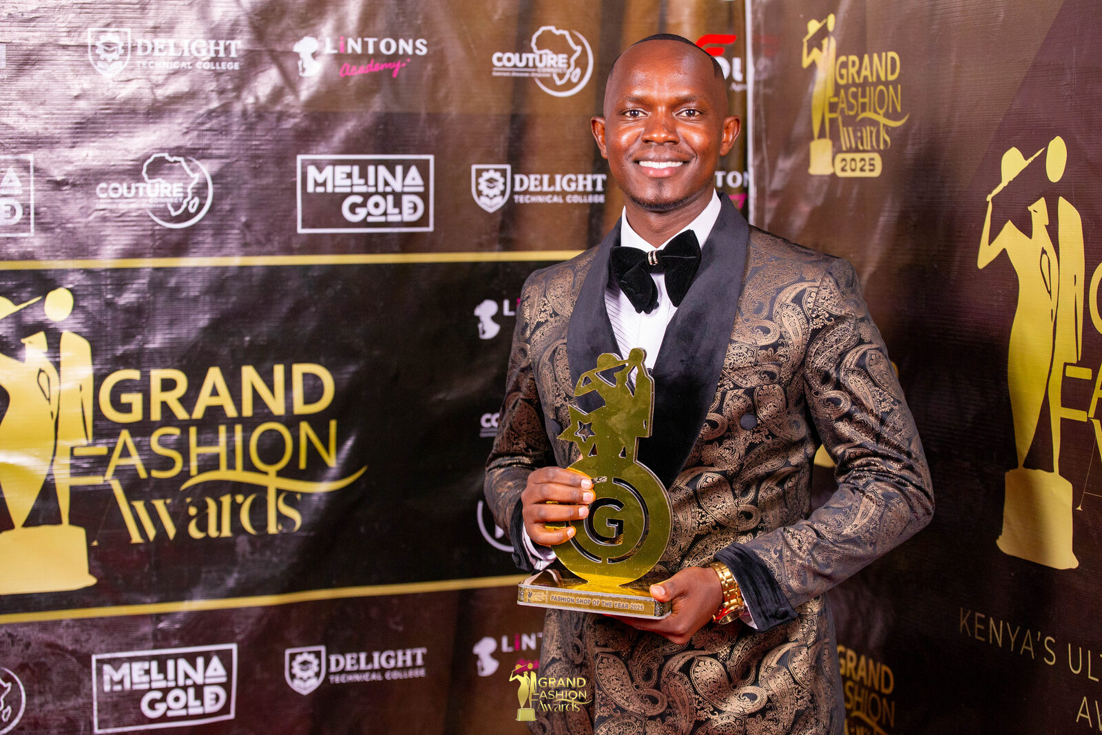 Winner holding his Grand Fashion Awards accolade